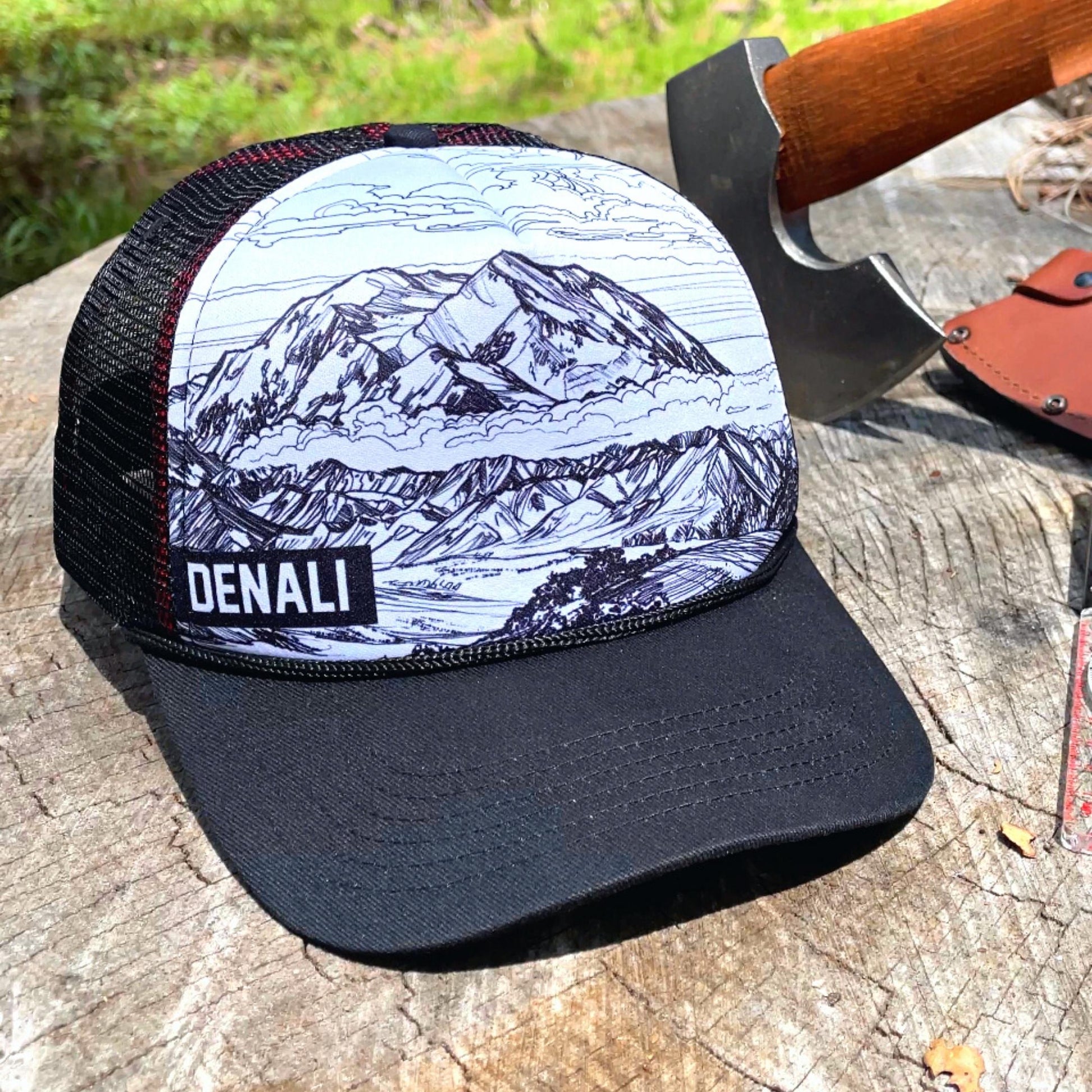 Denali Trucker Hat next to an axe on a tree stump | Hiker Sight