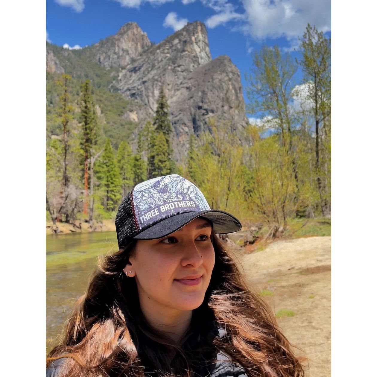 Girl wearing a Three Brothers trucker hat in front of Three Brothers mountains | Hiker Sight 